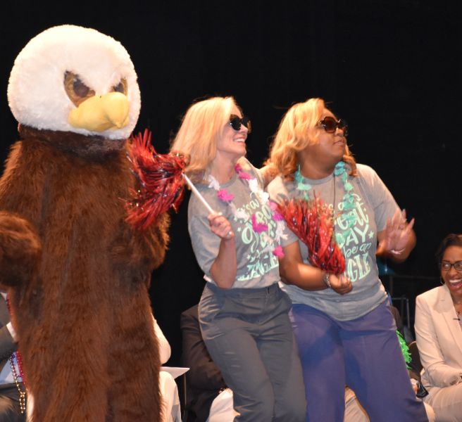  Eagle mascot dancing on stage with Horizon Elementary Eagles administrators